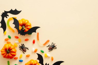 Kabak, şeker, yarasalar, metin için kopya alanı ile süslemeleri ile Modern Halloween arka plan. Pastel bej arka planda izole edilmiş. Düz yatıyordu, üstten bak, tepede. Cadılar Bayramı parti davetiye kartı mockup.