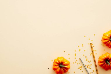 Cadılar Bayramı kompozisyonu. Cadılar Bayramı süslemeleri, kabaklar, pastel bej arka planda konfeti. Cadılar Bayramı parti davetiye kartı mockup. Düz döşeme, üst görünüm, kopyalama alanı