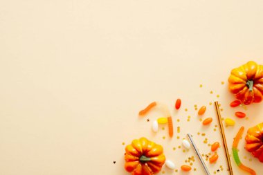 Cadılar Bayramı kompozisyonu. Cadılar Bayramı süslemeleri, kabaklar, pastel bej arka plan üzerinde şeker. Cadılar Bayramı parti davetiye kartı mockup. Düz döşeme, üst görünüm, kopyalama alanı