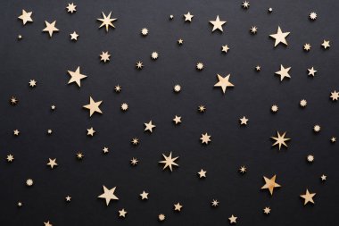 Noel kompozisyonu. Siyah arka plan üzerinde el yapımı ahşap yıldız . Noel arifesi, karanlık gece, Noel süsleri konsepti. Düz döşeme, üst görünüm, kopyalama alanı