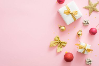 Hediye kutuları, altın süseşyaları, yıldız, yay, Noel süslemeleri ile Pembe Noel arka plan. Noel partisi davetiye kartı mockup, Yeni Yıl tebrik kartı şablonu. Düz döşeme, üst görünüm, kopyalama alanı