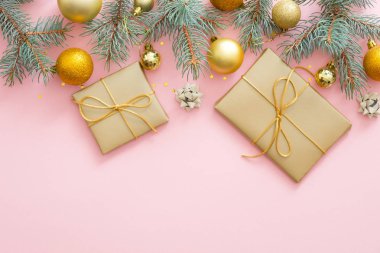 Noel kompozisyonu. Köknar ağacı dalları, hediye kutuları, altın topları, konfeti, pastel pembe arka plan süslemeleri. Düz döşeme, üst görünüm, kopyalama alanı. Noel, kış, Yeni Yıl konsepti.