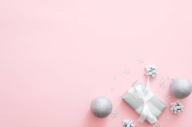 Noel süslemeleri, şık gümüş hediye kutuları, baubles, pastel pembe arka plan konfeti. Minimal düz döşeme stili kompozisyon, üst görünüm, kopyalama alanı. Noel moda glamour kavramı