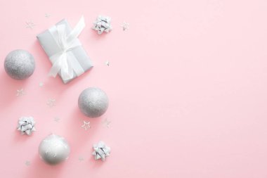 Kopya alanı ile pastel pembe arka plan noel gümüş süslemeler. Düz yatıyordu, üstten bak. Noel tebrik kartı mockup, sosyal medya afiş şablonu. Glamour moda Noel kutlama konsepti