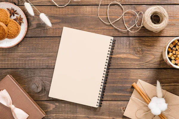 Zanaat kağıt not defteri, ip, çay fincan, çerezleri, hediye kutusu, vintage zarf ile Çalışma alanı. Şık ev ofis masası. Sonbahar veya Kış konsepti. Düz döşeme, üst görünüm