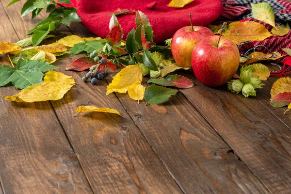 Flatlay sonbahar kompozisyon. Elmalar, bitki dalı, tahta masanın üzerine sonbahar düşmüş yapraklar. Düz döşeme, üst görünüm, kopyalama alanı. Ev masası masasında sonbahar hasadı.