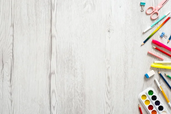 Geri okul konsepti, ahşap masa üzerinde çeşitli okul malzemeleri ve kırtasiye ile yaratıcı düzeni. Düz döşeme stili kompozisyon, üst görünüm, genel merkez.