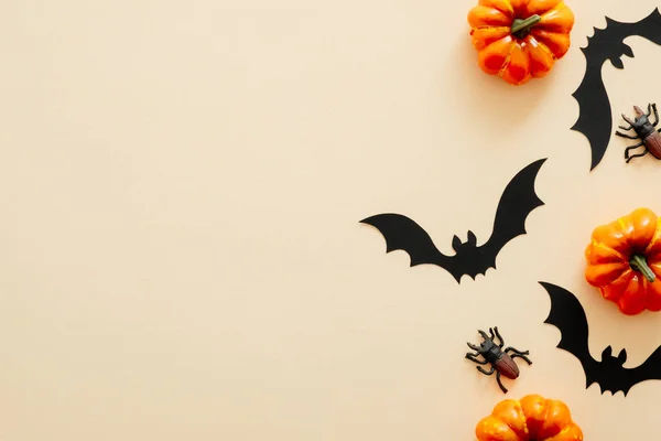 Moderno sfondo di Halloween con zucche, ragni, pipistrelli di carta con spazio per la copia di testo. isolato su sfondo beige pastello. Posa piatta, vista dall'alto, sopraelevata. Mockup biglietto invito festa di Halloween . — Foto Stock