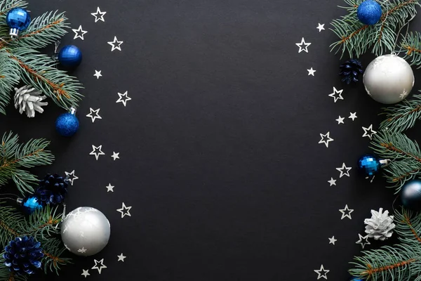 Borda de quadro de Natal com decorações modernas azuis e lascas, bugigangas, ramos de abeto, confete em fundo preto escuro. Mockup elegante banner de Natal, modelo de cartão de saudação — Fotografia de Stock