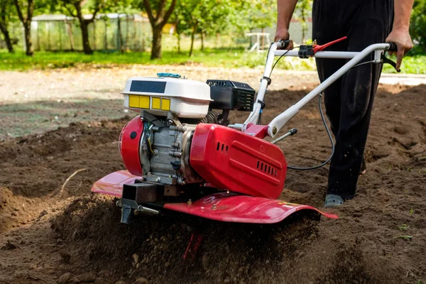 Mann arbeitet im Garten mit Gartenfräse. Gartenfräse zur Arbeit, hautnah — Stockfoto