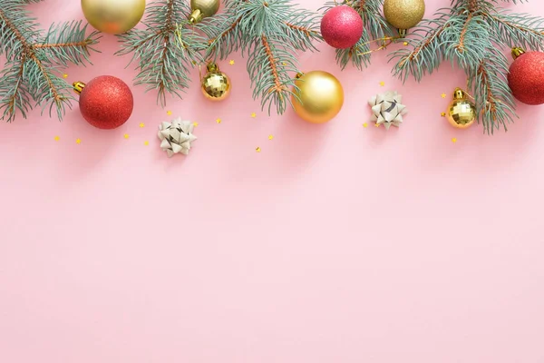 Cadre de Noël en boules scintillantes lumineuses, branches de sapin, décorations sur fond rose pastel. Modèle de carte d'invitation de fête de Noël, modèle de carte postale. Plat, vue sur le dessus, vue aérienne — Photo