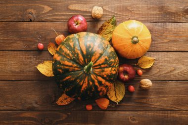Mutlu Şükran günü konsepti. Olgun turuncu kabaklar, düşmüş yaprakları, rustik ahşap masa üzerinde kuru çiçekler ile Yaratıcı düzeni. Düz döşeme, üst görünüm, kopyalama alanı.