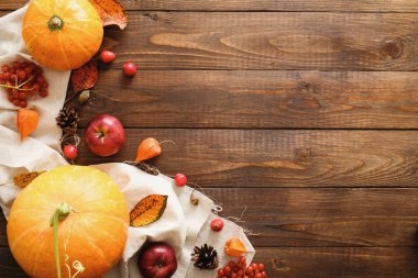 Mutlu Şükran günü konsepti. Olgun turuncu kabaklar, düşmüş yaprakları, kuru çiçekler, rustik ahşap masa üzerinde battaniye ile Sonbahar kompozisyon. Düz döşeme, üst görünüm, kopyalama alanı.