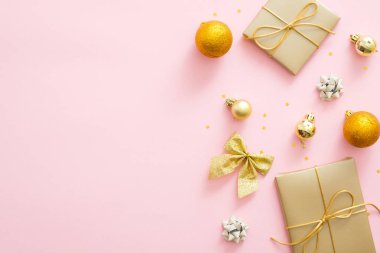 Hediyeler, yay, baubles, pastel pembe arka plan üzerinde altın Noel süslemeleri ile Noel arka plan. Düz döşeme, üst görünüm, kopyalama alanı. Glamour Noel partisi davetiye kartı mockup