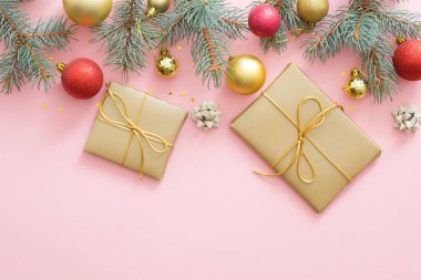 Noel tatili kompozisyonu. Xmas ağaç köknar dalları, renkli topları, pastel pembe arka plan üzerinde hediyeler kutusu. Noel, kış, yeni yıl konsepti. Düz döşeme, üst görünüm, genel merkez.
