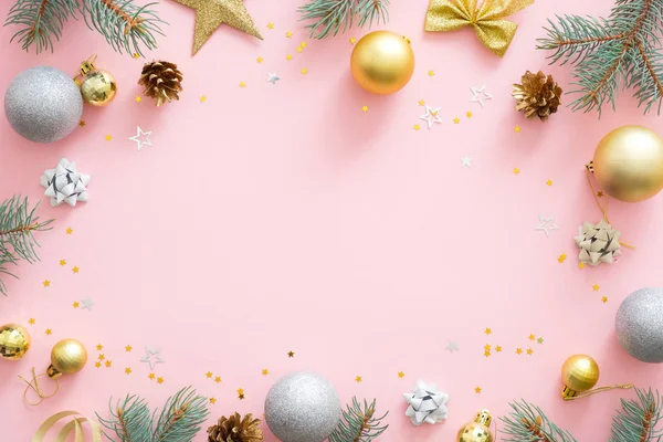 Рождественская рама из золотых и серебряных шаров, ель ветви, звезда, подарочные коробки, сосновые шишки на пастельно-розовом фоне. Плоская лежала, вид сверху, копировальное пространство. Рождество, зима, Новый год — стоковое фото