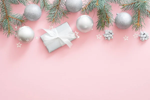 Composition des vacances de Noël. branches de sapin de Noël, boules d'argent, boîte cadeau sur fond rose pastel avec espace de copie. Couché à plat, vue de dessus. Modèle de bannière glamour de Noël, carte d'invitation . — Photo