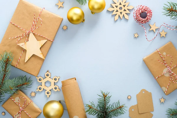 ギフトボックス、モミの木の枝、ロープのクルー、包装紙ロールと手作りの木製の装飾とブルークリスマスの背景。クリスマス、冬、新年のコンセプト。コピースペース付きのトップビュー. — ストック写真