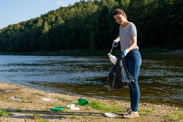 Mulher voluntária a apanhar lixo plástico na praia. Conceito de ambiente de limpeza — Fotografia de Stock