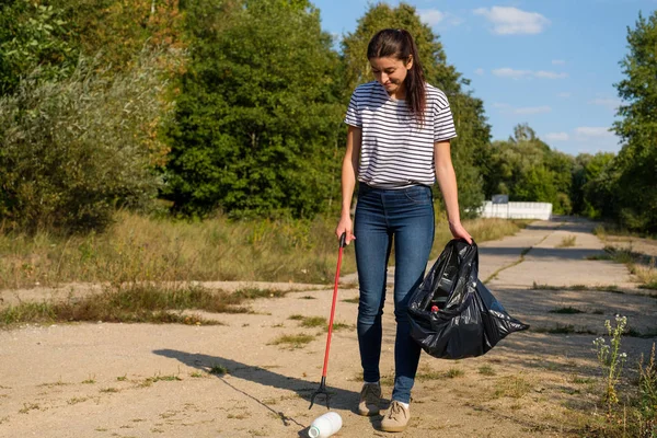 Mulher voluntária a apanhar lixo plástico na floresta. Conceito de ambiente de limpeza — Fotografia de Stock