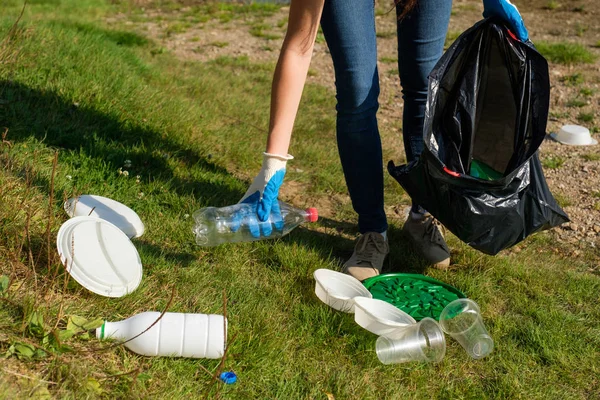 Ehrenamtliche Frau sammelt Plastikmüll im öffentlichen Park auf. Umweltkonzept zur Reinigung — Stockfoto