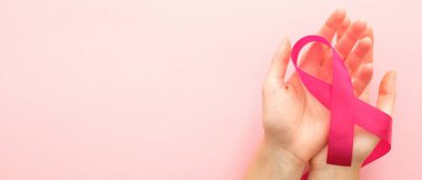 Kopya alanı ile meme kanseri farkındalık ay yatay afiş. Kadın el pembe arka plan üzerinde pembe kurdele tutan. Sağlık ve tıp konsepti.