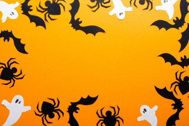 Mutlu cadılar bayramı tatil konsepti. Çerçeve Halloween süslemeleri, örümcekler, yarasalar, turuncu arka plan üzerinde hayaletler yapılmış. Kopya alanı ile Cadılar Bayramı parti tebrik kartı mockup. Düz döşeme, üst görünüm, genel merkez.