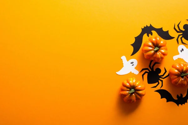 ハッピーハロウィーンホリデーコンセプト。ハロウィーンの装飾、クモ、コウモリ、幽霊、オレンジ色の背景にカボチャ。コピースペース付きのハロウィーンパーティーグリーティングカードモックアップ。フラットレイ、トップビュー、オーバーヘッド. — ストック写真