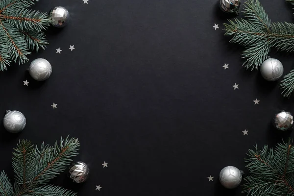 Köknar ağacı dalları, gümüş toplar ve konfetiyle siyah noel afişi. Noel çerçevesi, tebrik kartı şablonu, web pankartı modeli. Düz konum, üst görünüm, kopyalama alanı