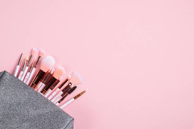 Makyaj fırçaları pembe arka planda. Düz yatış, üst görünüm.