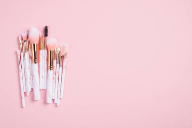 Pembe arka planda makyaj fırçaları. Düz konum, üst görünüm, kopyalama alanı.