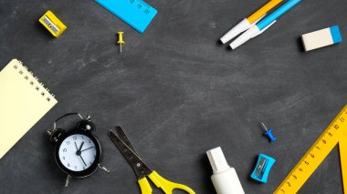 Tahta arka planda mavi ve sarı renkli okul malzemeleri. Düz yerde, üst tarafta, tepede. Okul konseptine dönelim..