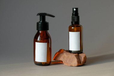 Kehribar cam kozmetik şişeleri. Pompa şişesinde doğal organik el jeli ve sprey şişesinde vücut losyonu. Güzellik ürünü paketleme tasarımı