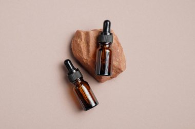 Kehribar cam göz damlası şişeleri taşın üzerinde etiket olmadan. Üst Manzara. Lüks güzellik ürünü ambalaj tasarımı