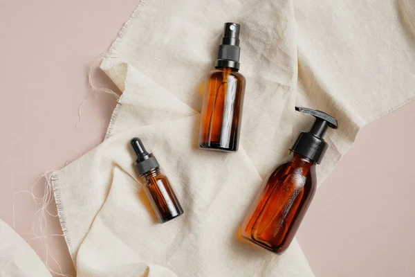 Set of amber glass cosmetic bottles, natural organic beauty product packaging design. SPA bathroom cosmetics.