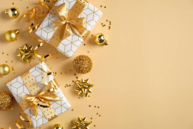 Altın Noel süsleri, hediye kutuları, toplar, sarı arka planda konfeti. Yeni yıl ya da Noel kartı ya da tebrik kartı. Düz konum, kopyalama alanı olan üst görünüm.