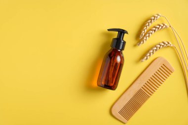 Saç tedavisi konsepti. Düz plastik kehribar cam şişe dağıtıcısı, saç jölesi, ahşap tarak, buğday. Manzaralı arpa ve yulaflı güzellik ürünü.
