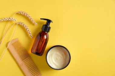 Buğday, arpa ve yulaf şampuanı jölesi, nemlendirici krem ve sarı arka planda saç fırçası. Doğal bitki kozmetik ürünleri. Saç tedavisi kavramı.