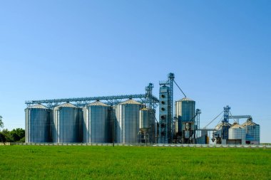 Tarım sektörü konsepti. Tahıl depolama, kurutma, tarımsal ürünler, un, tahıl ve tahıl için metal siloları olan tarım ve üretim fabrikaları