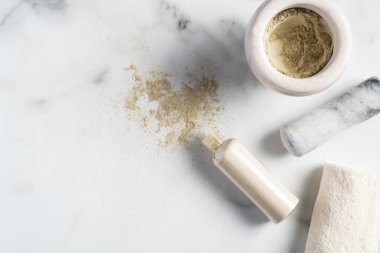 Ubtan yüz maskesi malzemeleri, mermer masa üzerinde toz ve havlu dolu bir kase. SPA doğal kozmetik, yüz bakımı konsepti.