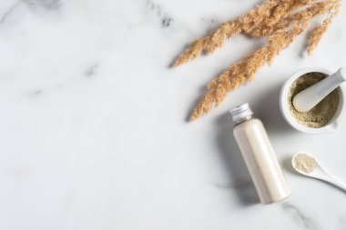 Ubtan kozmetik yüz maskesi hazırlama, kozmetik paketi. Kasede Ubtan tozu ve mermer masada havan topu. Ayurvedik güzellik ürünü.