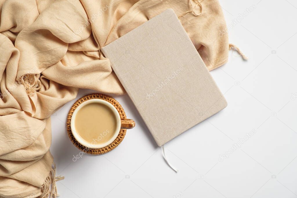 Modern home office desk with beige plaid, coffee cup, paper notebook on white background. Elegant feminine workspace. Top view, flat lay.