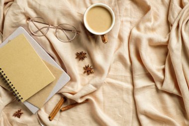 Sonbahar yassı kompozisyonu. Kağıt defter, bardaklar, bej ekose kahve fincanı. Sonbahar hygge tarzı masa masası veya kış tatili konsepti.