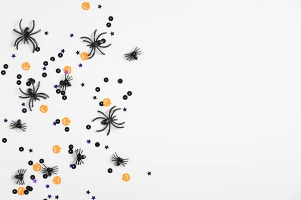 White halloween background with spiders and confetti. Top view with copy space, flat lay. Happy Halloween holiday concept. Halloween sale banner mockup