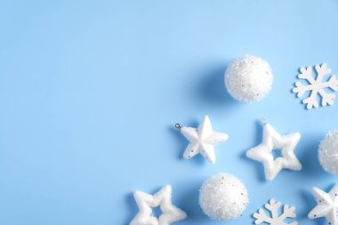 Beyaz Noel süslemeleri, yıldızlar, kar taneleri, mavi arka planda toplar. Noel tebrik kartı modeli, kartpostal şablonu. Düz yatış, üst görünüm, en düşük biçim.