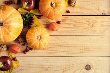 Şükran Günü konseptin kutlu olsun. Olgun turuncu balkabaklarıyla sonbahar kompozisyonu, dökülen yapraklar, kırsal ahşap masadaki kuru çiçekler. Düz konum, üst görünüm, kopyalama alanı.