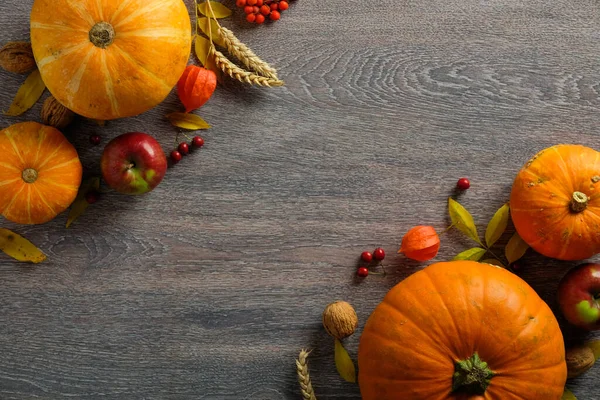 Sonbahar kompozisyonu. Olgun su kabakları, sonbahar meyveleri, koyu masa üzerindeki kuru yapraklar. Hasat ya da Şükran Günü konsepti. Düz konum, üst görünüm, kopyalama alanı.