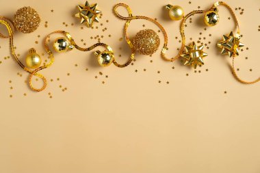 Altın Noel süslerinden, toplardan, kurdeleden, sarı arka planda konfetiden yapılmış çerçeve sınırı. Düz konum, üst görünüm, kopyalama alanı. Noel kartı şablonu, Yeni Yıl afişi modeli.
