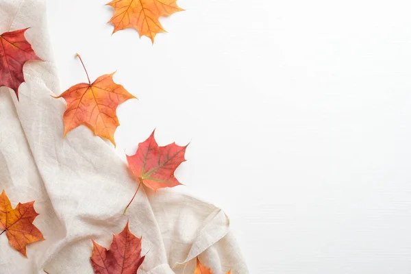 秋天的框架由五彩缤纷的枫叶和米黄色的面料在白色的背景 简约风格秋季作曲 顶视图 — 图库照片