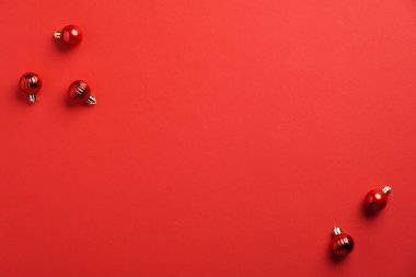 Kırmızı arka planda kırmızı süslemeli Noel afişi. Xmas tebrik kartı şablonu. Düz yatış, üst görünüm.